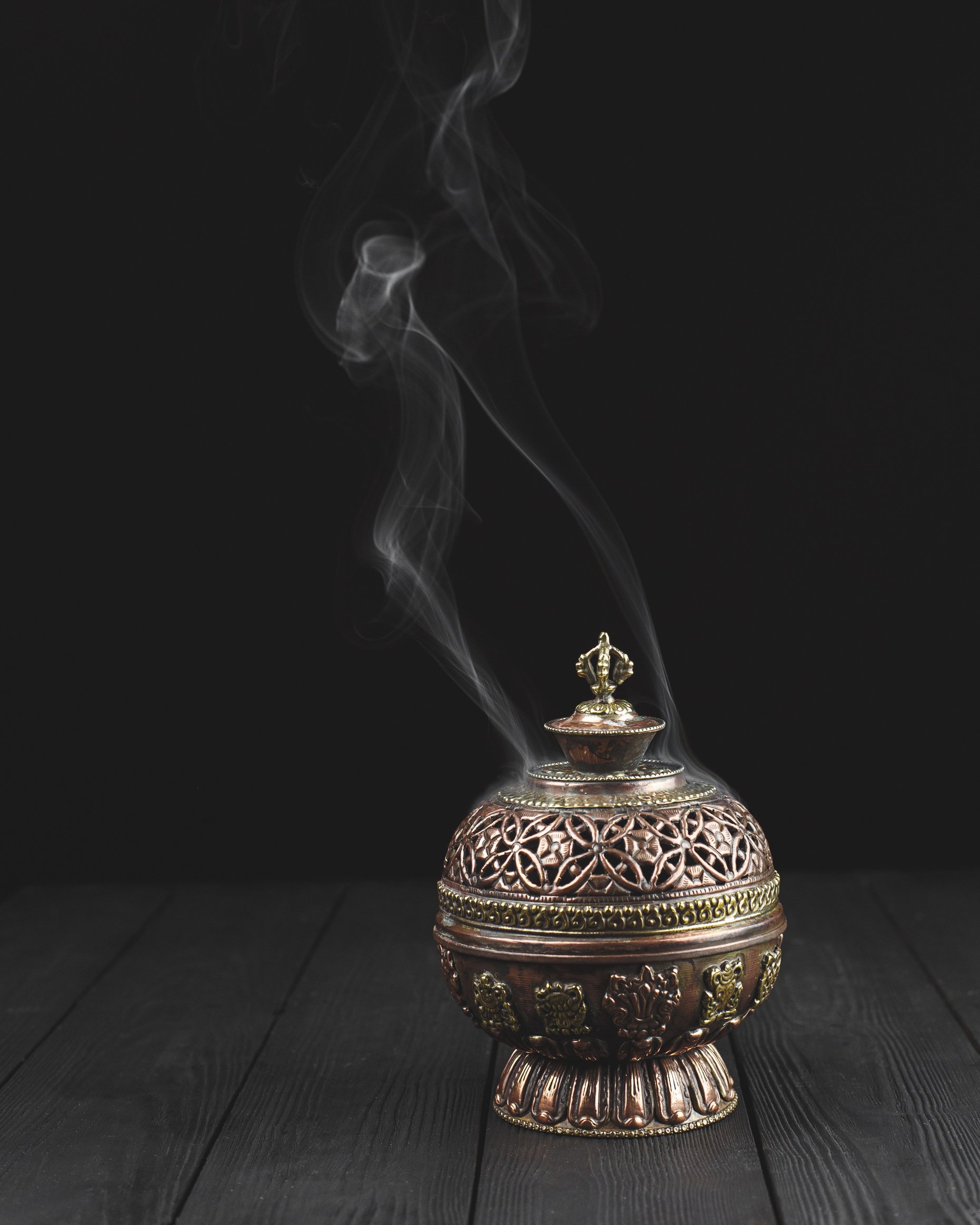 Copper incense holder on dark wooden background bukhoor burner white smoke